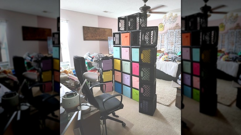 Black milk crates with multicolored fabric storage bins dividing bedroom