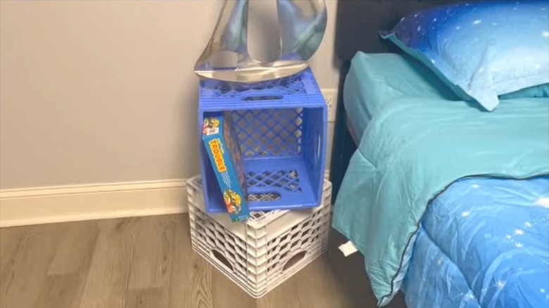 two milk crates stacked as nightstand with storage for books and lamp beside bed