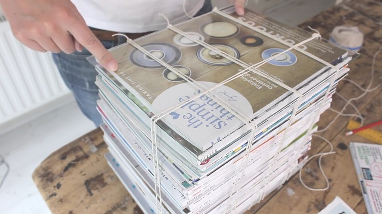 Lifestyle magazines stacked and wrapped in white twine as improvised end table