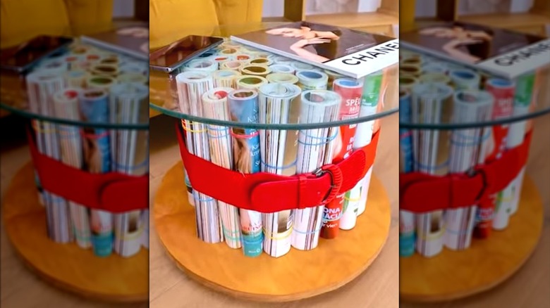 Rolled up magazines as stand for glass table in living room