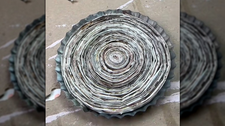 Recycled magazine pages rolled into drink coaster on crafting surface