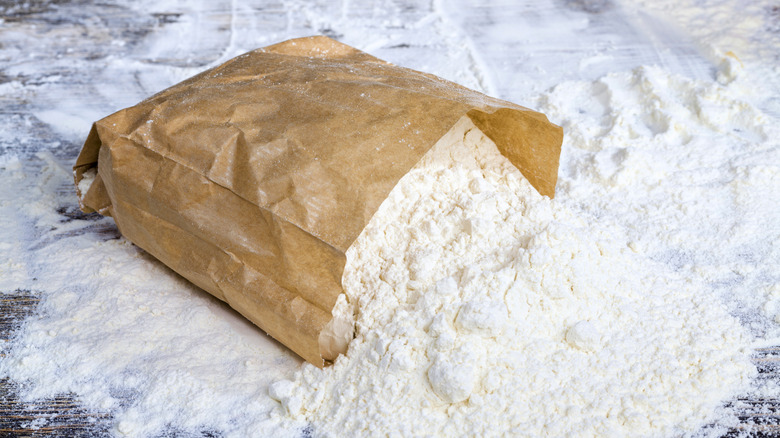 Spilled brown bag of white flour.