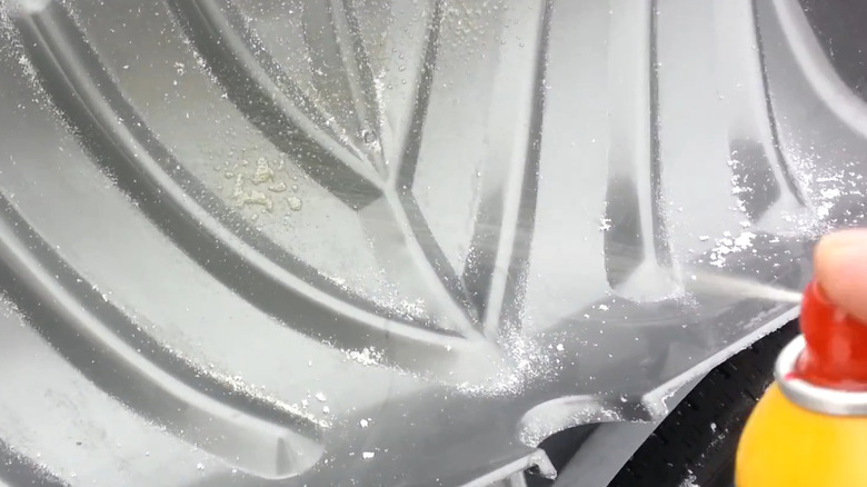 Applying olive oil cooking spray to a snow shovel