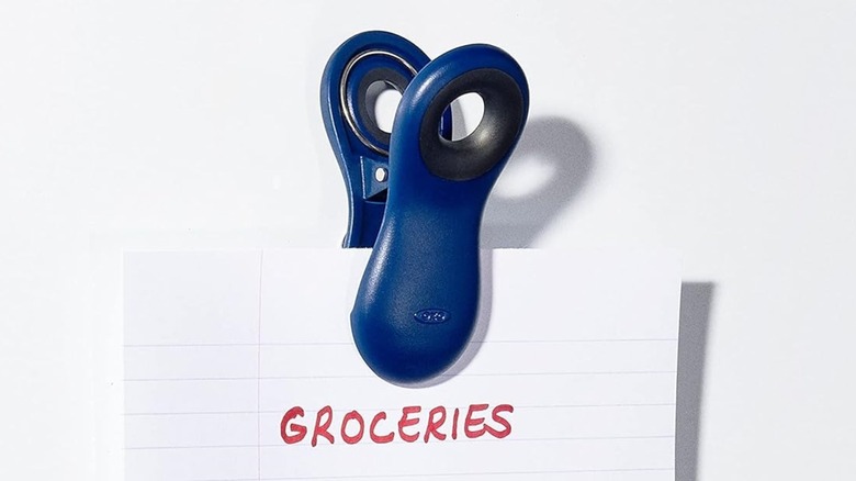 Oxo All Purpose Magnetic Clips holding a piece of paper that says "Groceries"