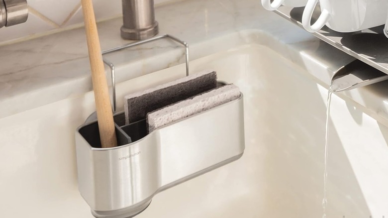 A Simplehuman Sink Caddy on the side of a kitchen sink