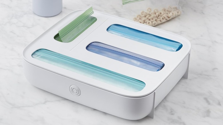 A YouCopia StoraBag Drawer Food Bags Dispenser on a marble countertop