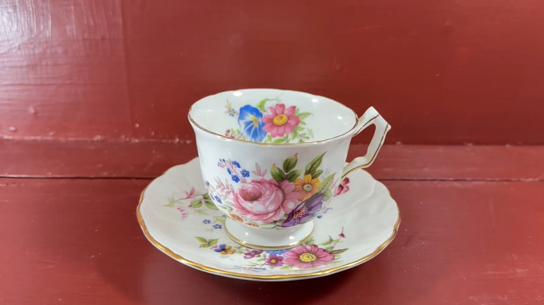 A floral vintage Aynsley teacup on a red table