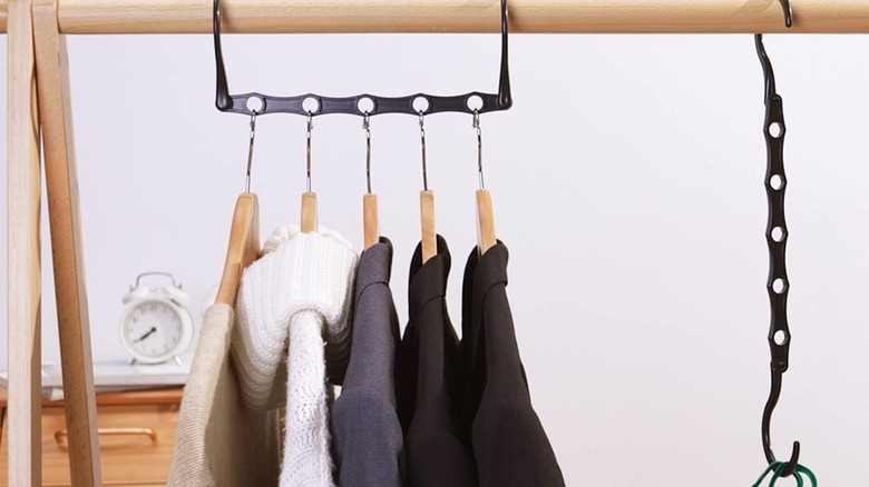 Clothes hanging from a black hanger with several holes in it