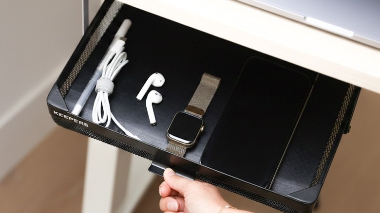 Hand pulling out a drawer under a desk