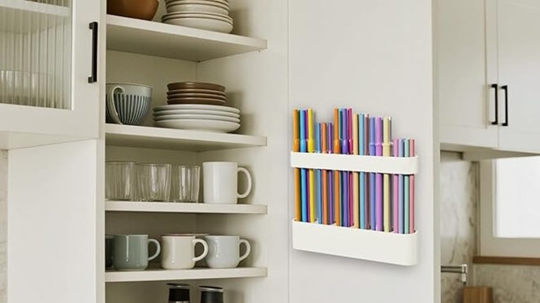 A silicone straw organizer installed on a cabinet door