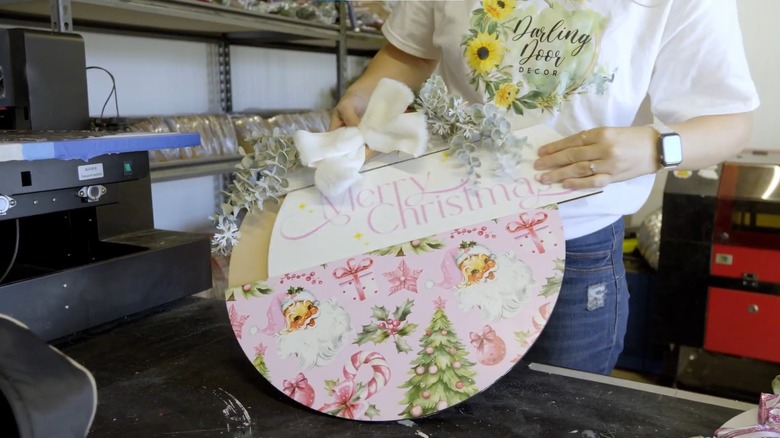 Woman swapping out the design on a wood plaque front door decoration