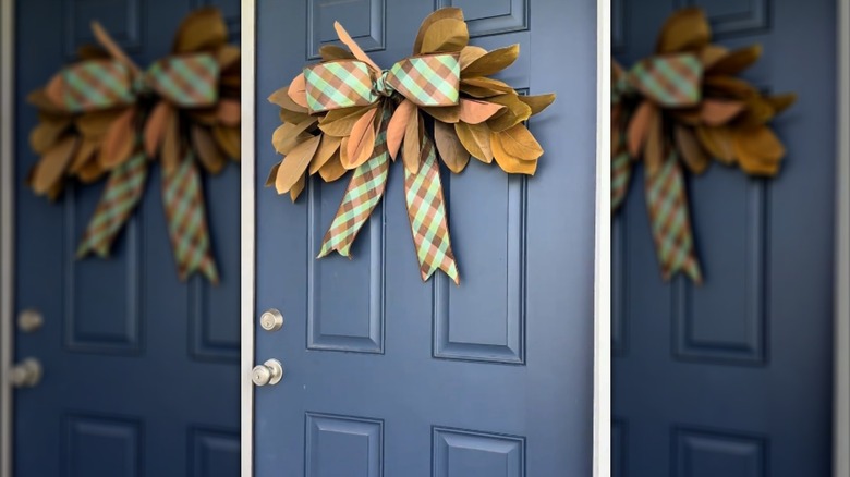 Large plaid bow with orange leaves on dark blue front door