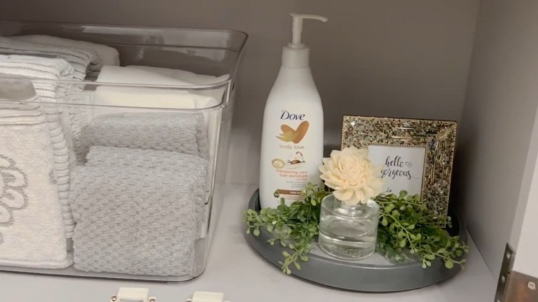 Turntable stored inside a cabinet with lotion and other items