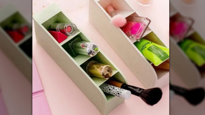 Different colored pen holders sitting on a shelf with cosmetics inside