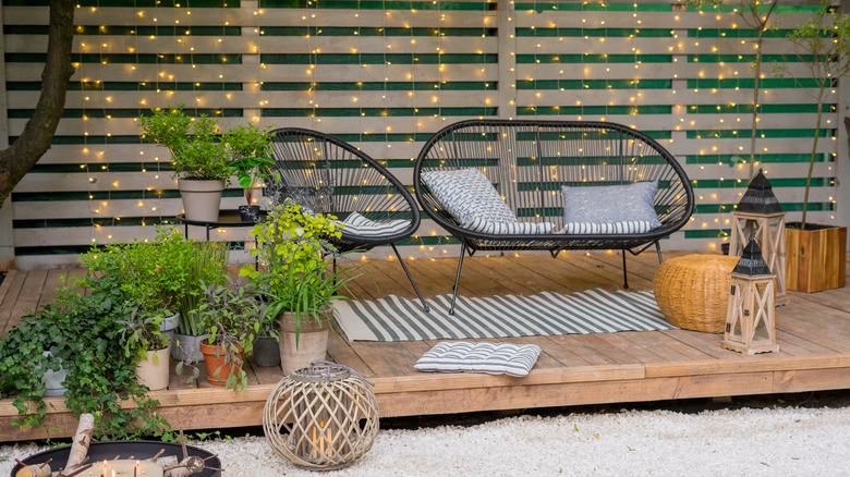 Patio space with chairs and multiple potted plants