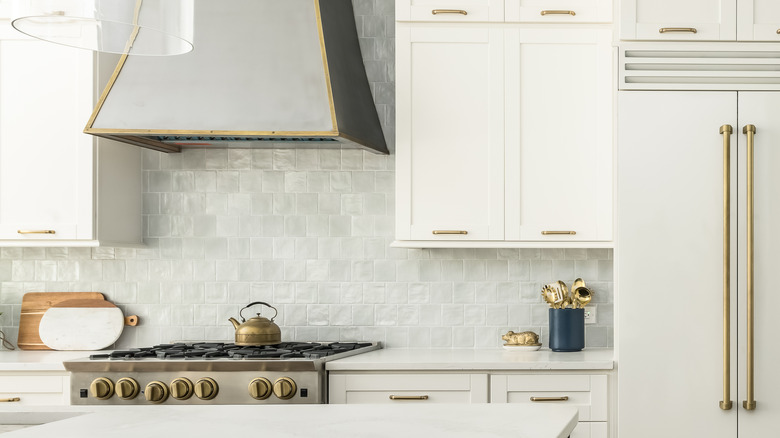 Kitchen with a large brass-trimed range hood