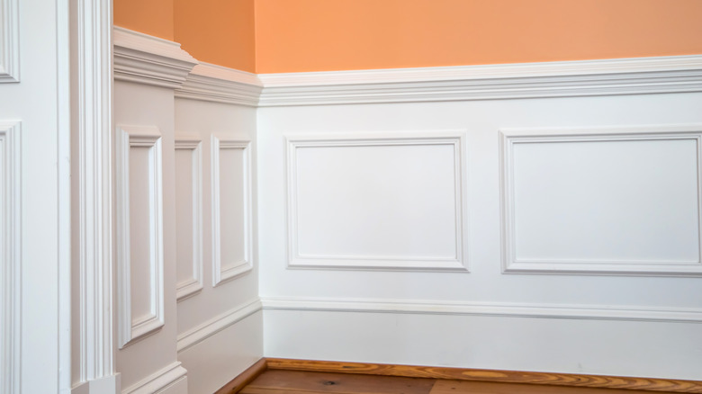 White chair rail above wainscotting on a peach wall