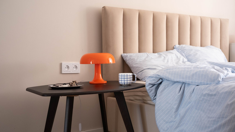 Bright orange mushroom lamp on a bedside table