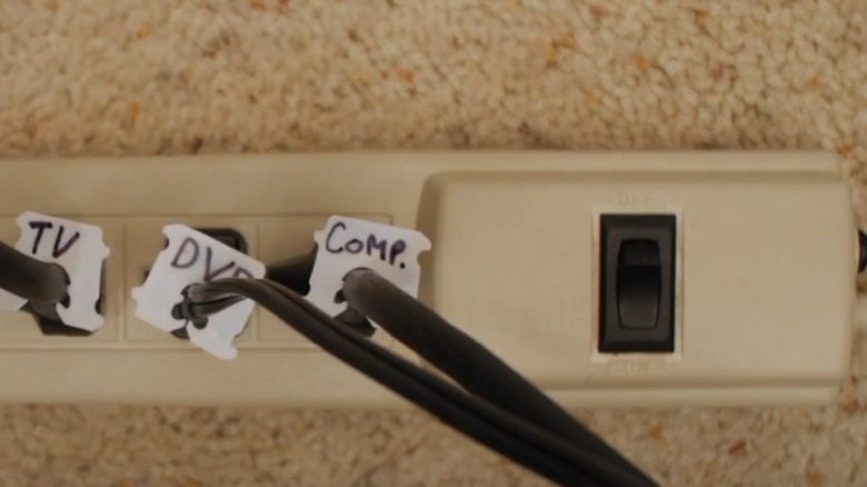 Three electronics cables labeled by appliance plugged into a power strip.