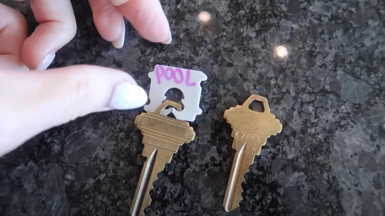 Hands reaching for keys tagged and labeled with a bread tab.