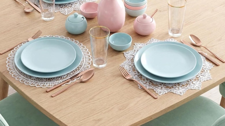 Lacy placemats under blue plates for soft chic place setting in dining room