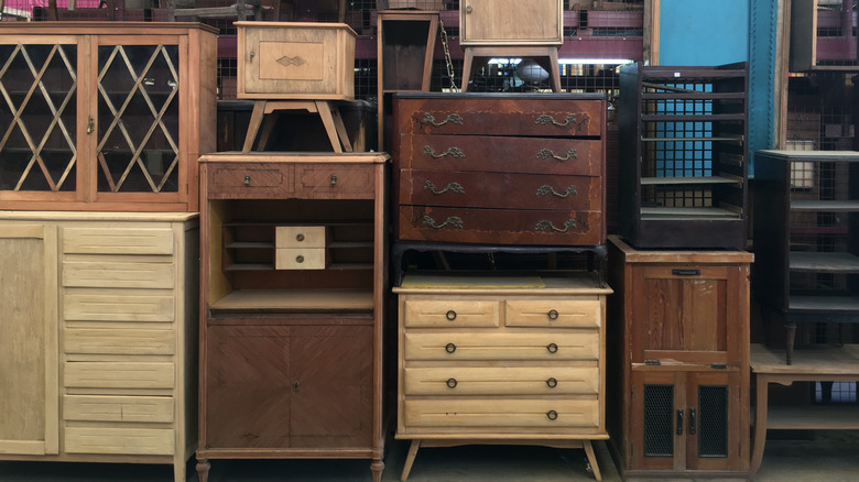 Stacks of vintage wooden dressers at a flea market