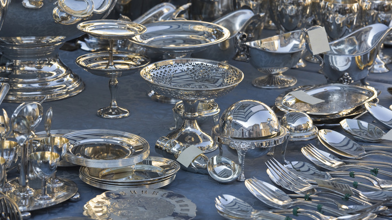 Table of vintage silverware, serving utensils, and flatware
