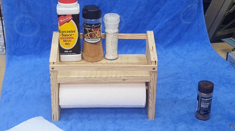 DIY wooden shelf for assorted spices and paper towel on blue tarp