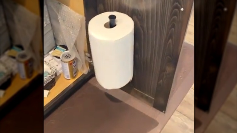 paper towel on black rod upright on inside kitchen cabinet door