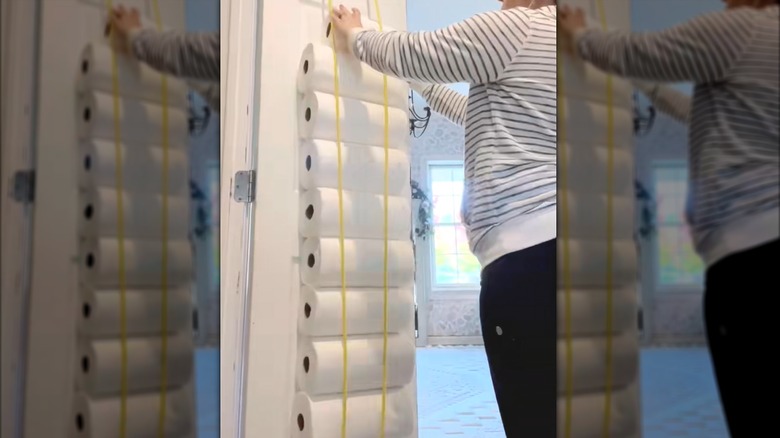 Yellow bungee cord holding paper towels against inside door