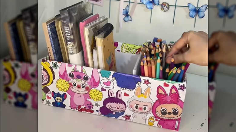 Homemade Labubu desk organizer holding notebooks and colored pencils.