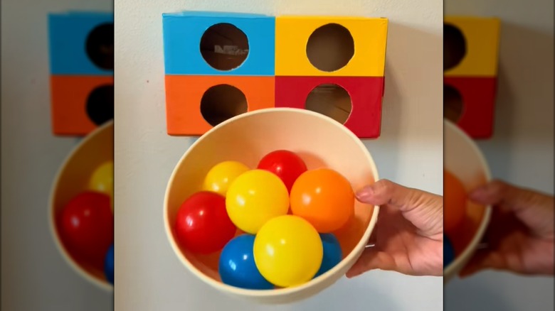 Bowl of plastic balls and divided shoe box for DIY learning game.