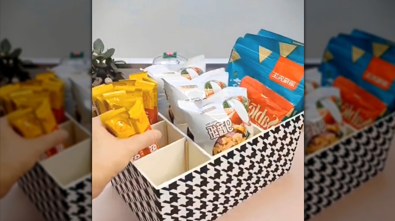 Patterned shoebox restyled as a divided snack container for chips and sweets.