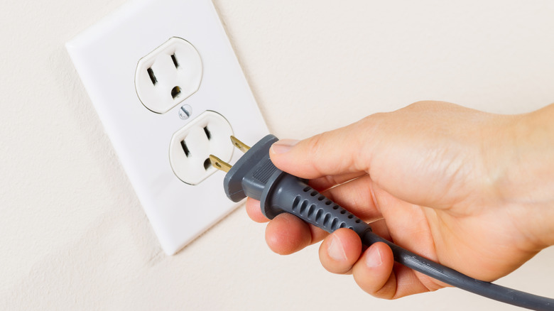 A person plugging something into an outlet
