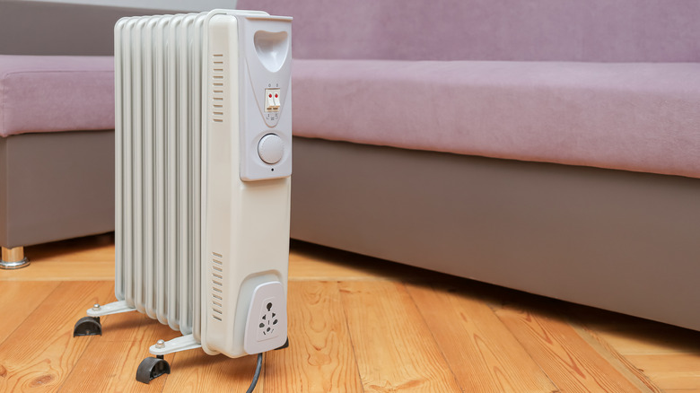 A gray space heater beside a couch