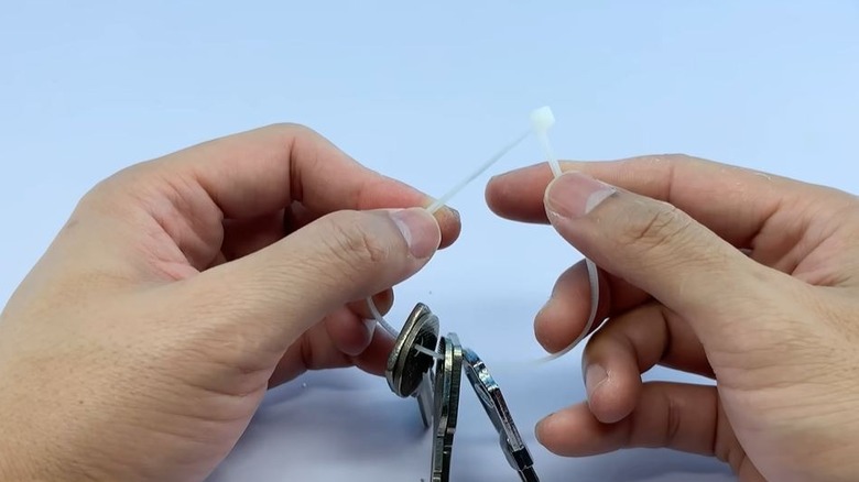 Man making keyring from zip tie