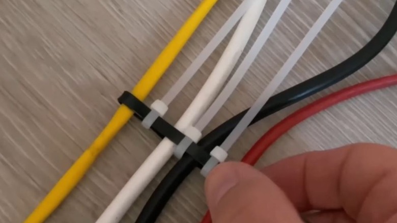 Man organizing cords using zip ties