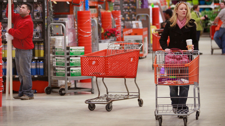 A woman pushes a cart through the aisles at Home Depot