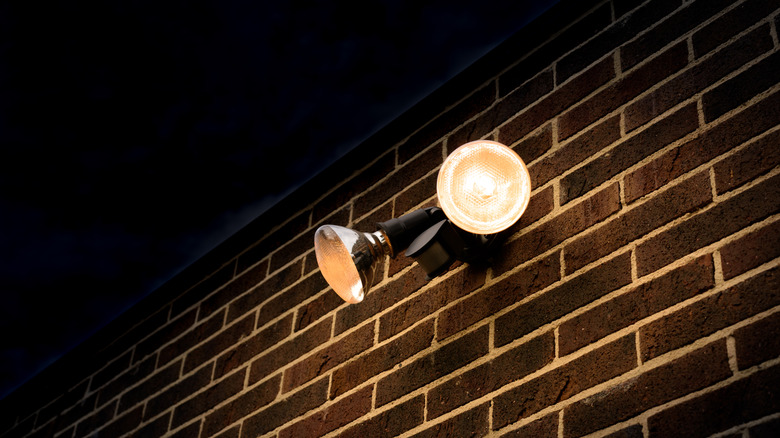 Two flood lights illuminating a brick house