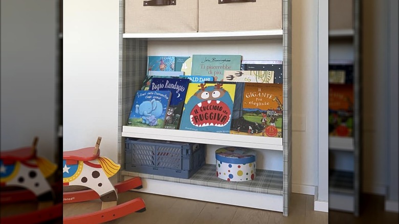 White and gray IKEA BILLY children's bookcase with MOSSLANDA picture frames on shelves