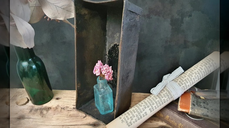A vintage loaf pan turned into a display holder for a vase