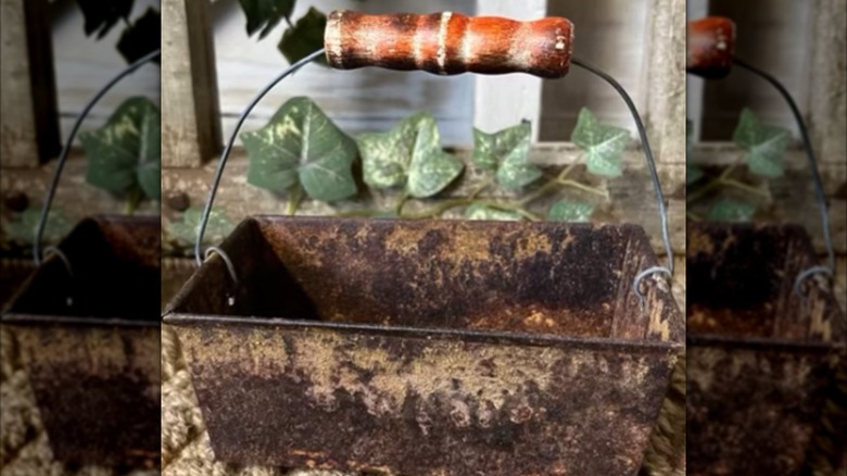 A rusted bread pan turned into a small basket with handle.