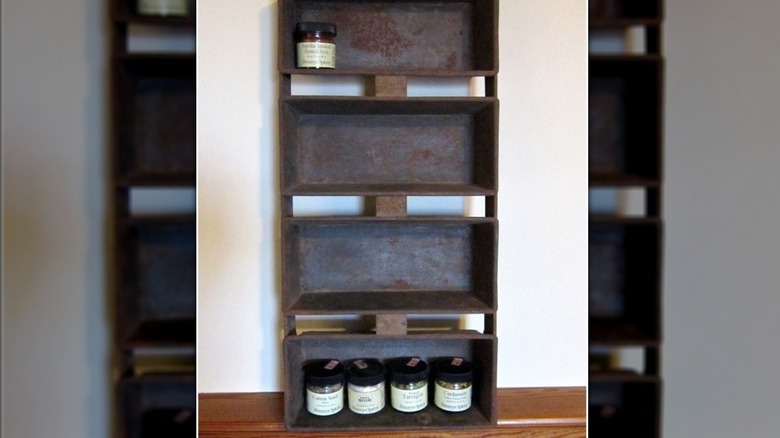 Four loaf pans serve as the base of a spice rack in a kitchen