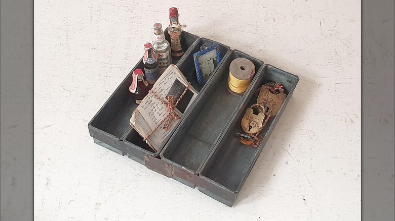 A four compartment bread loaf pan used as a catchall.