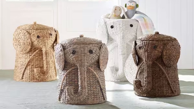 Four elephant-shaped natural woven baskets sit next to each other on a gray floor