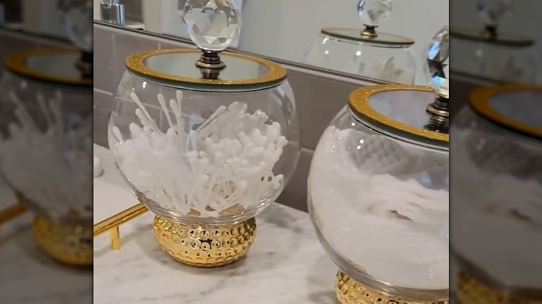 Gold and glass bathroom organizers with Q-tips and cotton pads