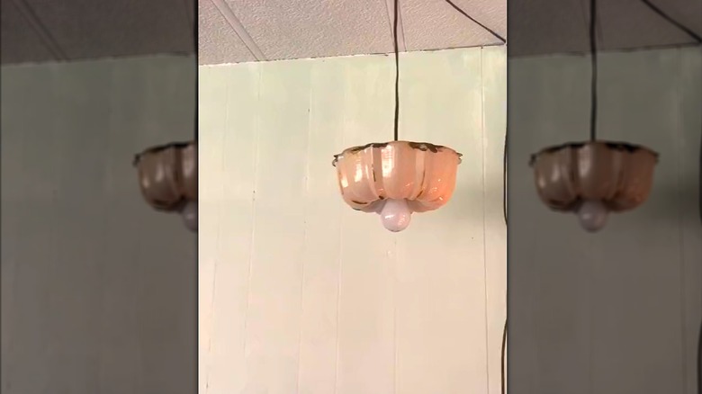 Vintage hanging pendant light from repurposed cooking pan beside plain wall and ceiling