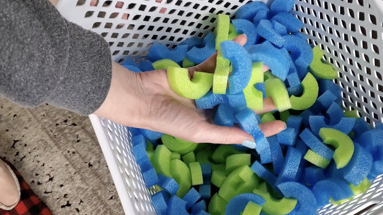 Woman holding packing peanuts made by pool noodles