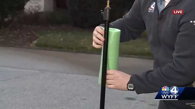 Local meteorologist covering pipe with pool noodle