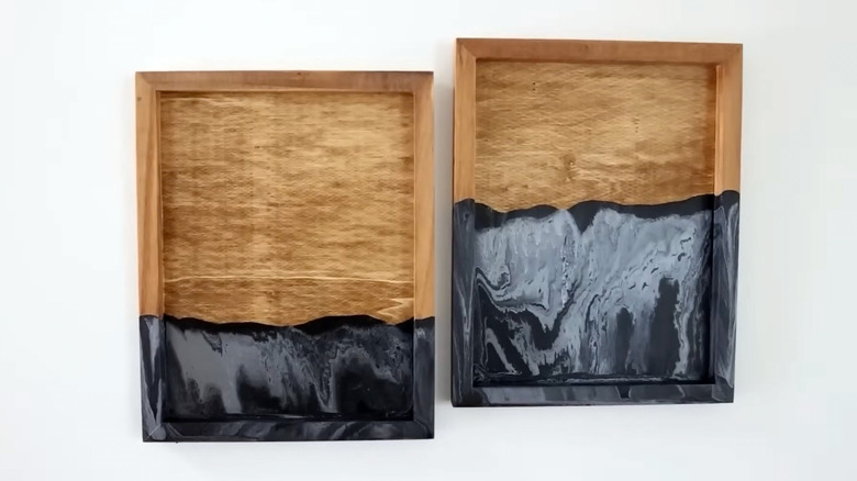 Two drip-painted trays hang on a white wall